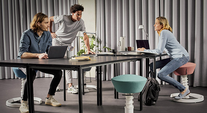 Zwei Männer auf Swopper sitzend am Schreibtisch mit Laptop - Bild zu Kundenmeinungen