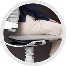 Seitliche Nahaufnahme der konvex geformten Sitzfläche des ergonomischen Bürostuhls Aeris 3Dee mit sitzender Person.