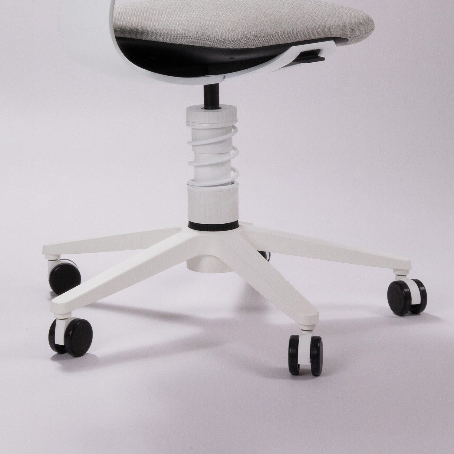 Unterer Bereich des ergonomischen Stuhls Aeris 3Dee, mit weißem Gestell, sichtbarem Federbein sowie Fußkreuz mit Rollen.