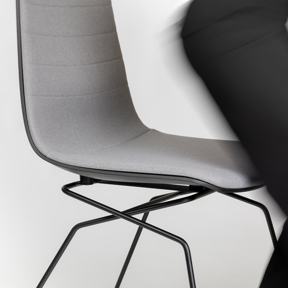 Seitliche Aufnahme eines ergonomischen Stuhl Aeris Linu mit schwarzem Gestell, Person steht vom Stuhl auf.