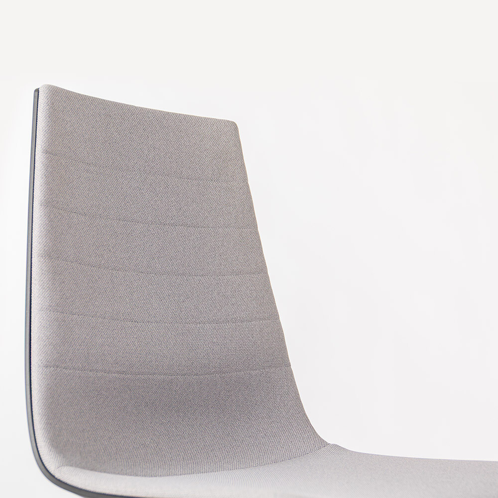 Nahaufnahme der grauen Rückenlehne des Bürostuhls Linu, welche die elegante Längssteppung und integrierte Lordosenstütze zeigt.