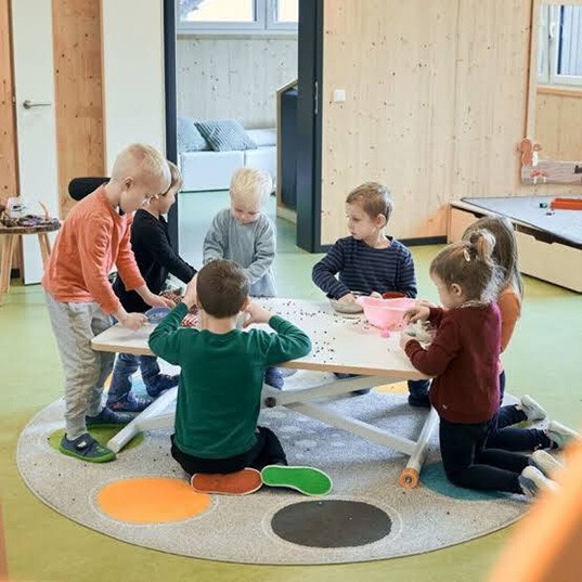 Kindergartengruppe spielt gemeinsam am Tisch